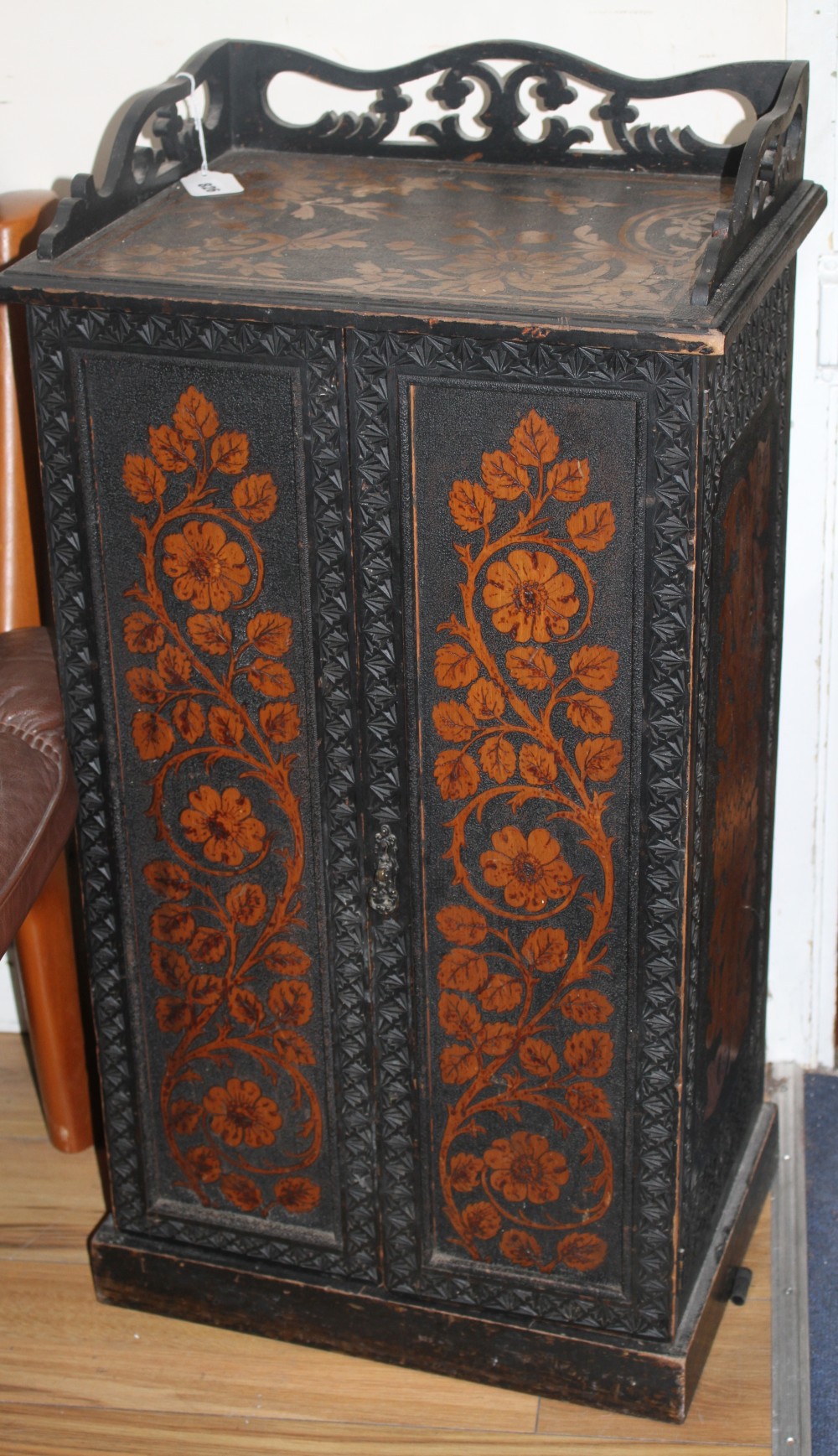 An Edwardian ebonised music cupboard, with floral pokerwork decoration, W.47cm D.35cm H.91cm